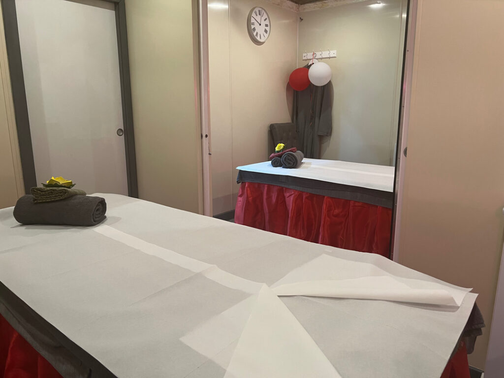 Calm and inviting massage therapy room with two tables, each adorned with neatly folded towels and decorative flowers, set for a relaxing and therapeutic experience in Woolmer Green.