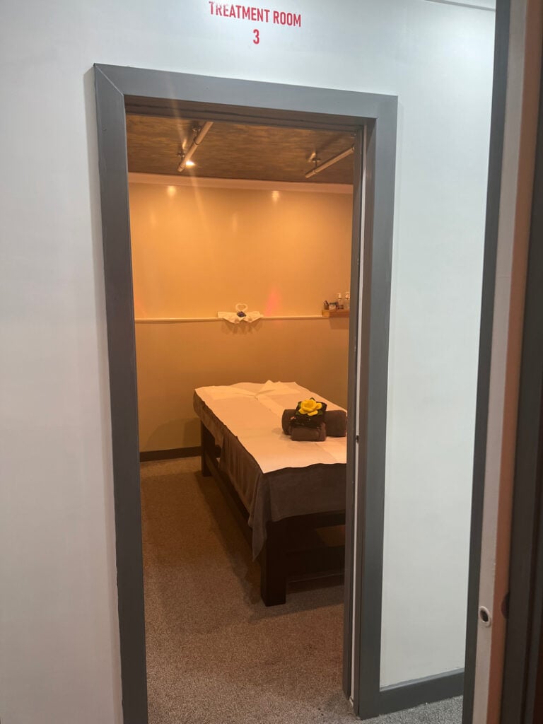 Treatment room in Woolmer Green featuring a massage table prepared with fresh linens and folded towels, creating a serene atmosphere for a relaxing massage therapy session.